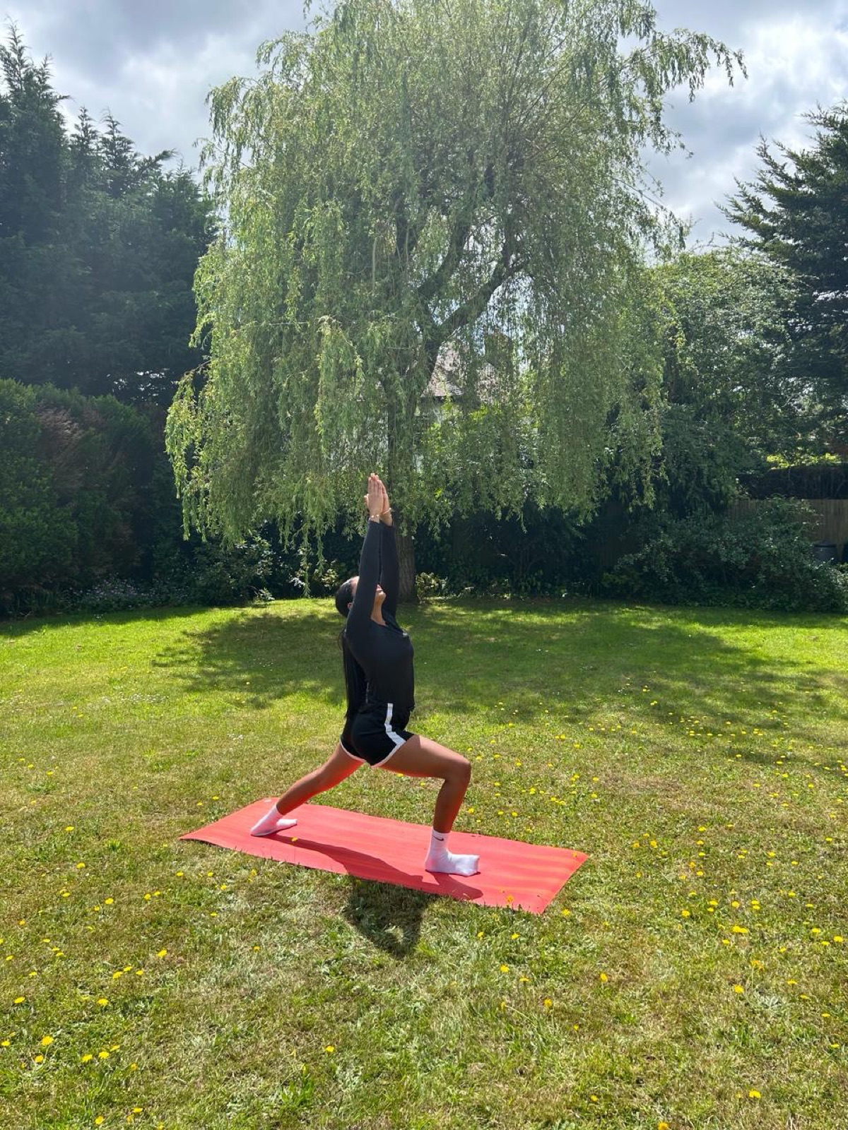 Pallavi practising crescent lunge in a garden