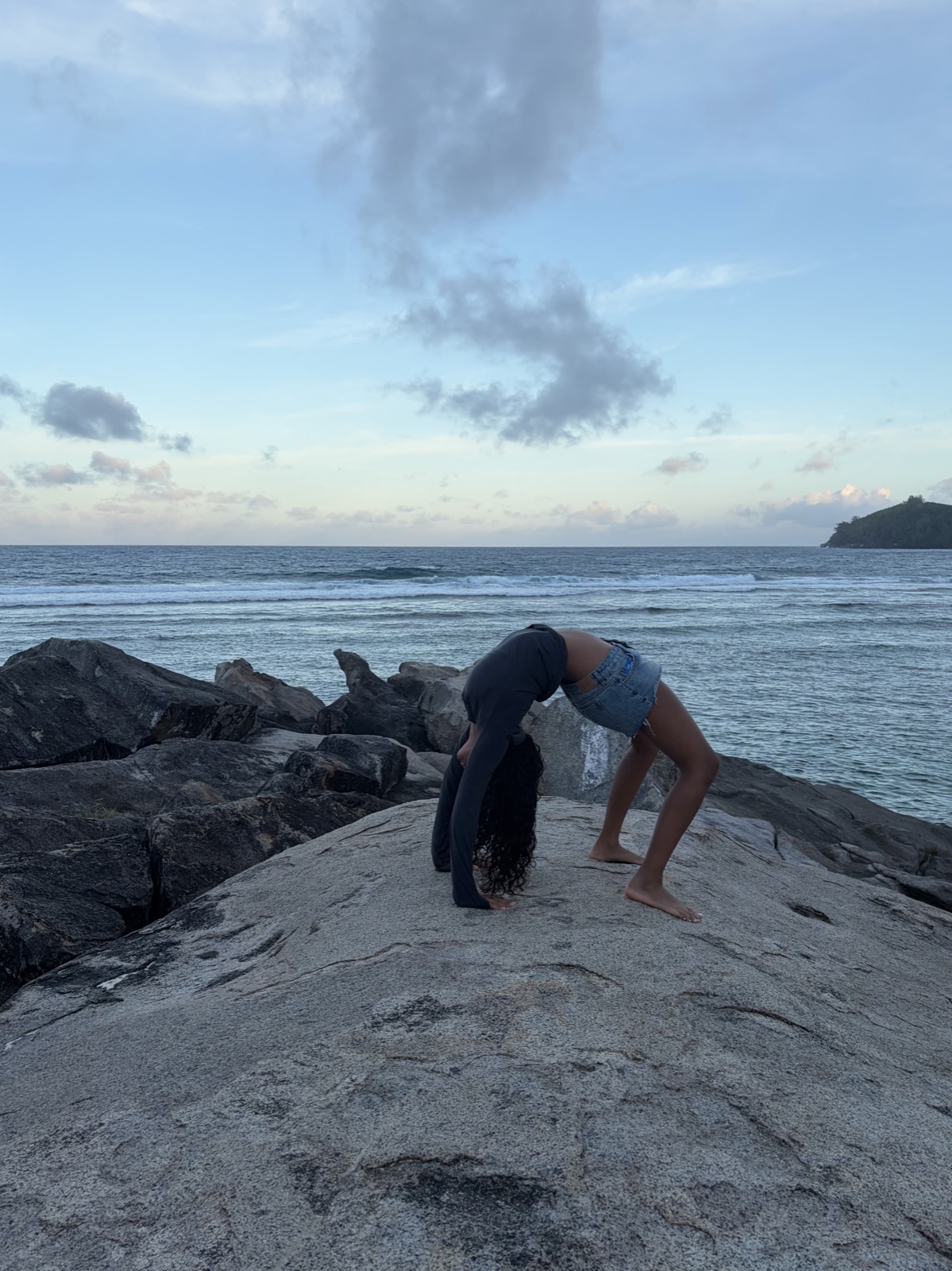 Wheel pose on coastal rocks above the sea at dusk